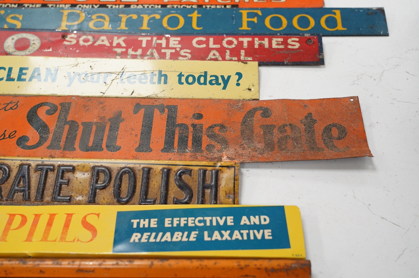 Eleven early / mid century tinplate advertising shelf strips, largest 60cm. Condition - poor to fair